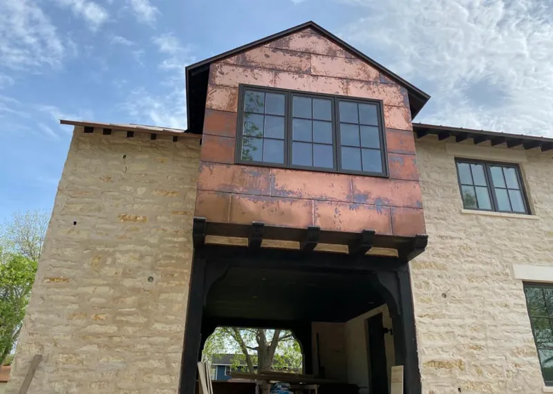 Copper metal panel facade on a stone building for Skylight Installation in Las Flores